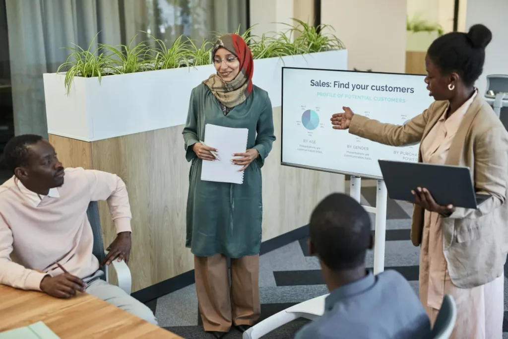Tim profesional berdiskusi strategi penjualan dalam rapat bisnis di kantor modern